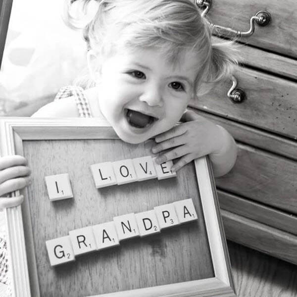 fathers day ideas for grandpa with granddaughter holding "I Love Grandpa" sign"