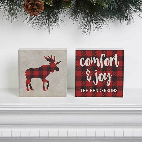 Personalized plaid decor with two plaid pictures, one of a moose silhouette and the other with the quote, 'comfort & joy, the hendersons'