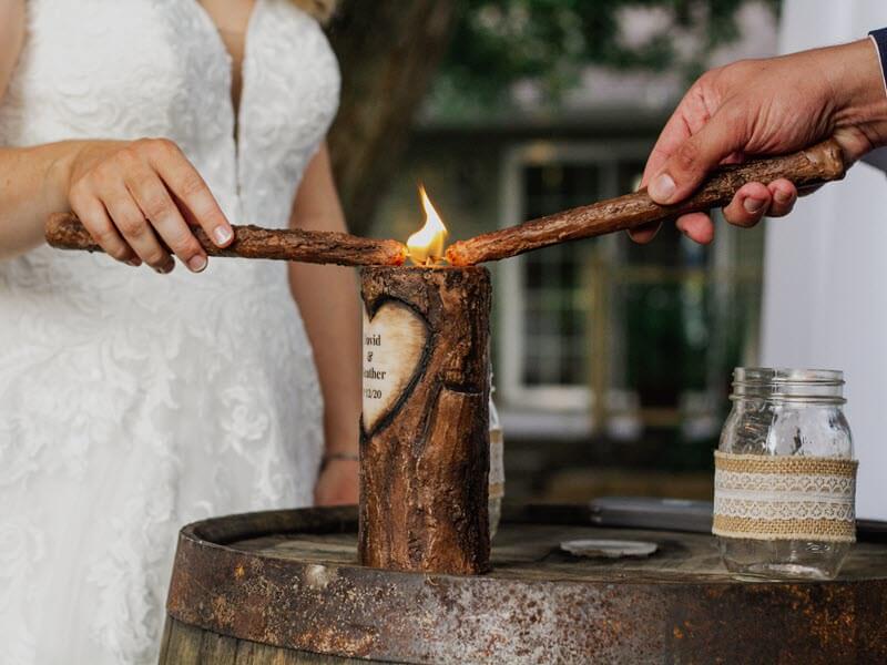 2023 wedding trends with bride and groom lighting candle