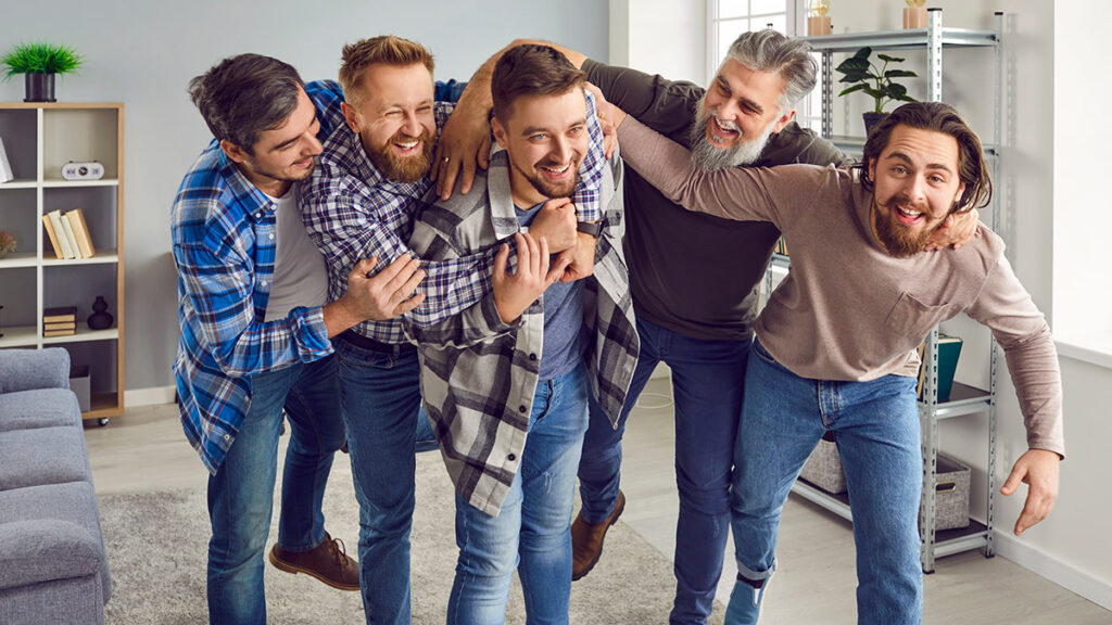 Group of joyful, excited men congratulating their friend on a happy event in his life