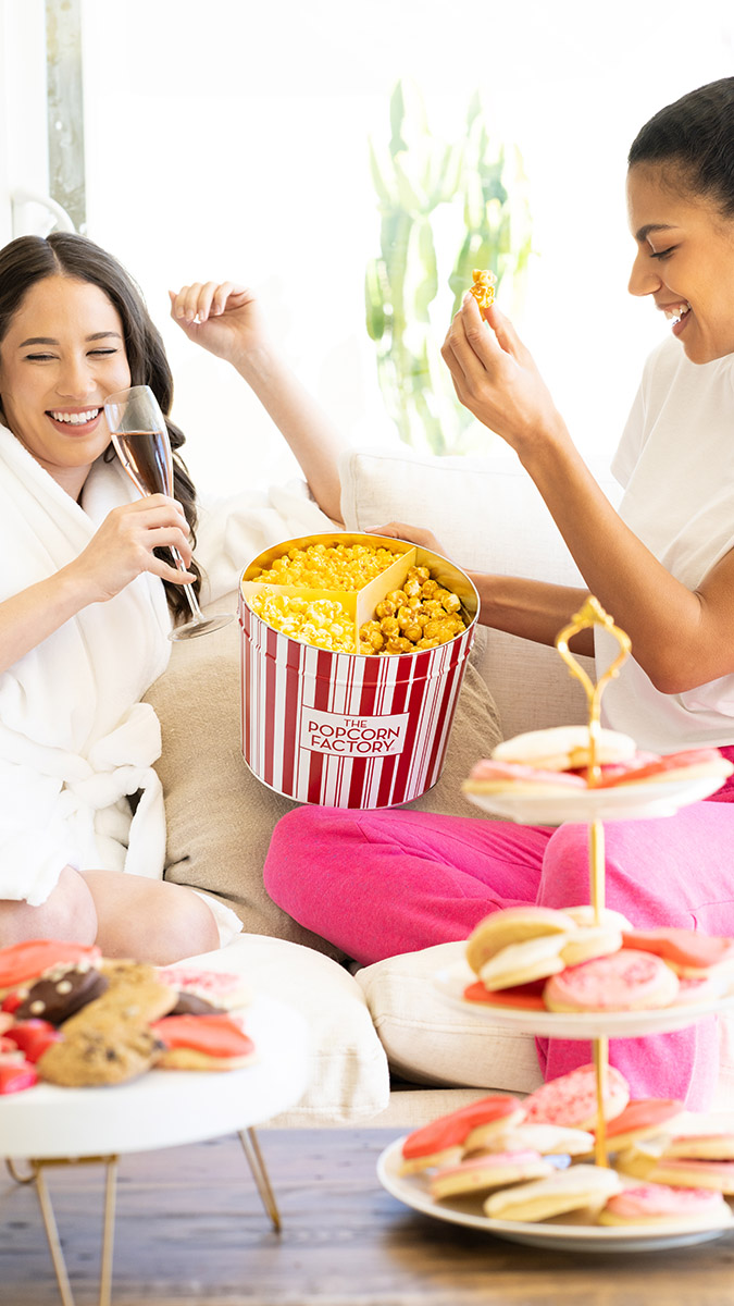 galentines day party ideas girlfriends laughing while eating popcorn
